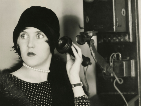 woman on old fashioned telephone looking away